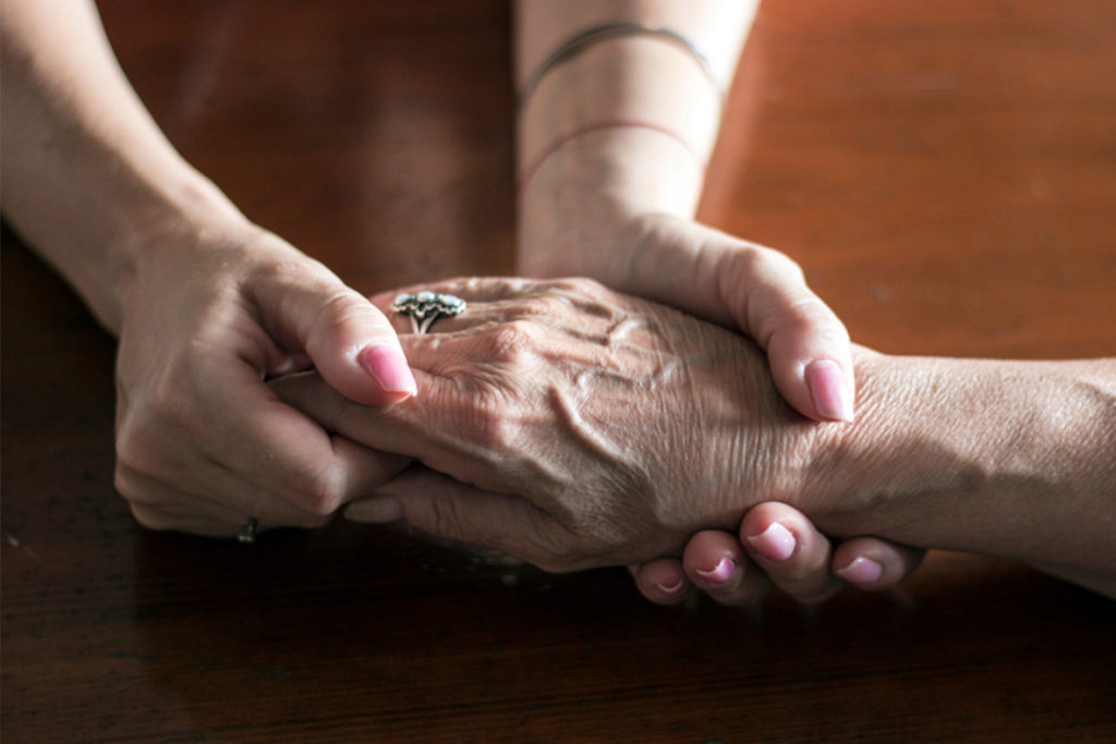 woman holding elderly woman's hand