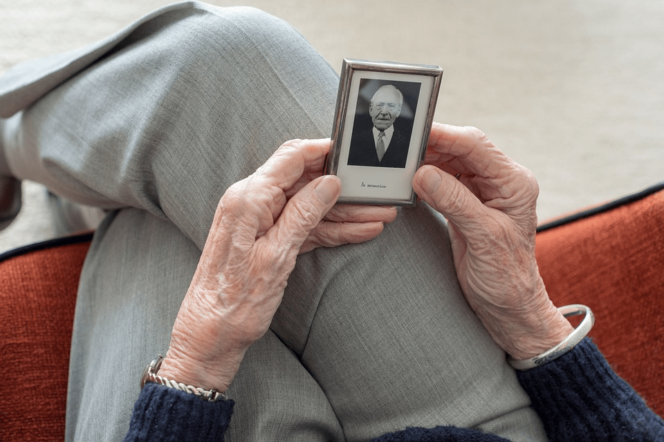 elderly lady holding photo of man