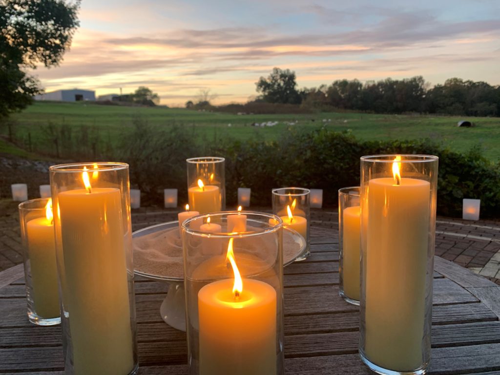 candles in front of a field at sunset