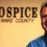 John Thoma with Hospice of Wake County sign