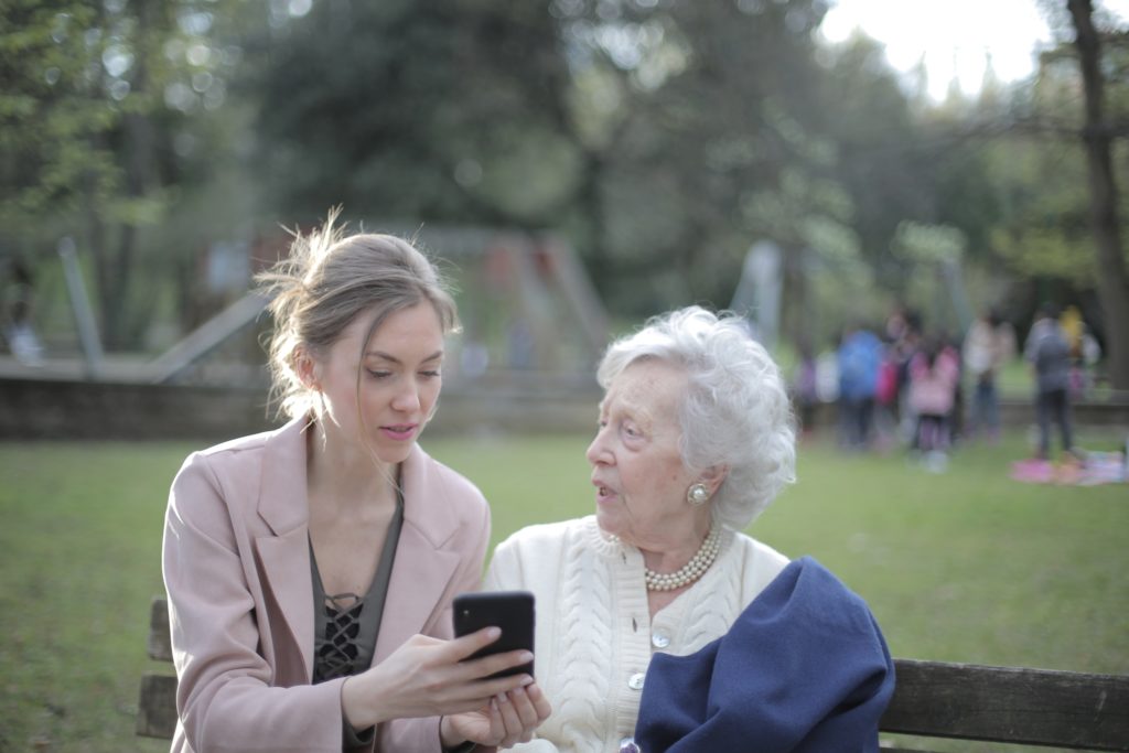 young women showing older woman a phone